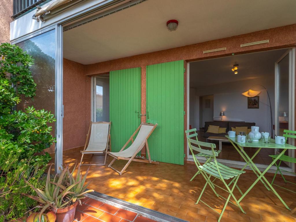 un patio avec un mur végétal et des chaises et une table dans l'établissement Apartment Les Palmiers by Interhome, à Hyères