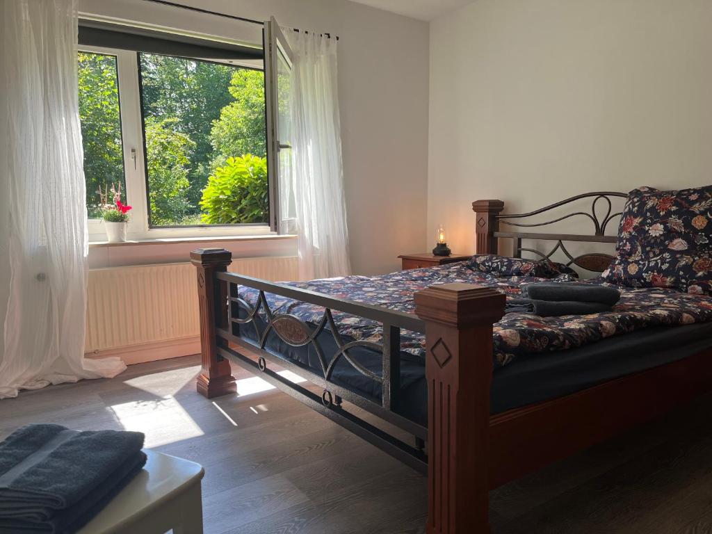 a bedroom with a bed and a couch and a window at Haus Kanalliebe in Nübbel