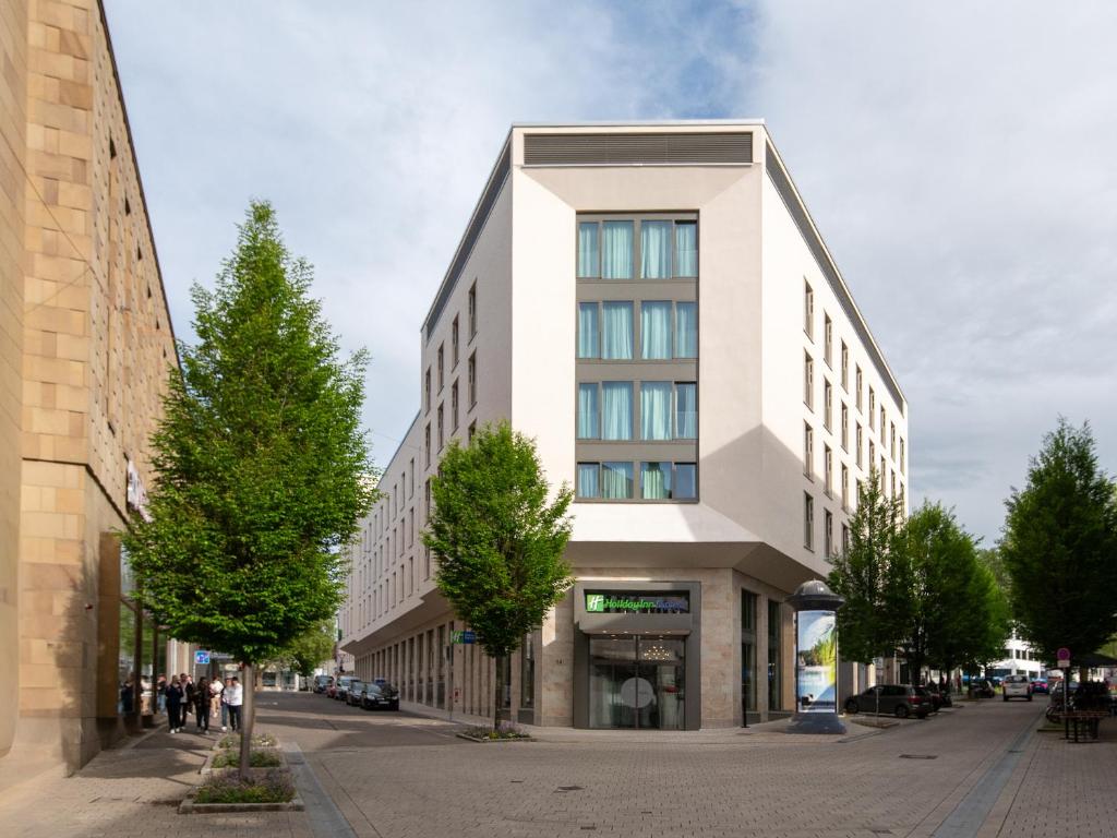 un edificio blanco alto en una calle de la ciudad en Holiday Inn Express Heilbronn, an IHG Hotel, en Heilbronn