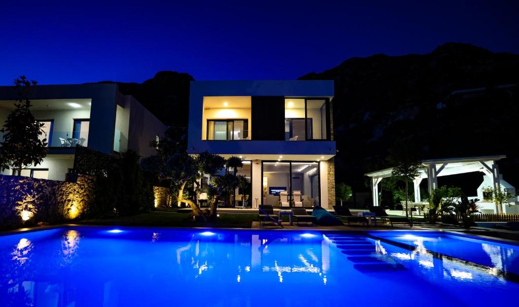 a villa with a swimming pool at night at Villa White Pearl in Palasë
