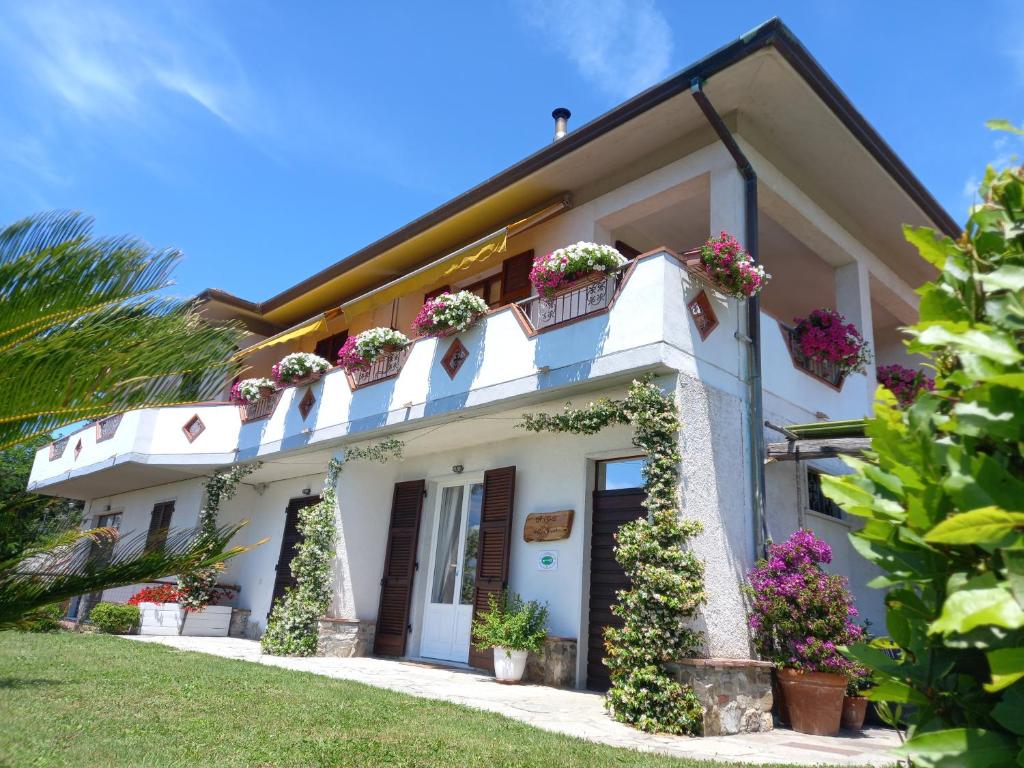 a white house with flowers on the balconies at Il Colle della Brina in Sarzana