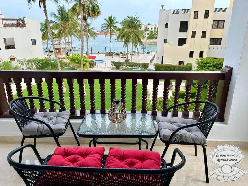 a patio with a table and chairs and a view of the beach at New Luxury 2 BD Marina Hawana Suite Sea View, Salalah in Wādī Khasbar