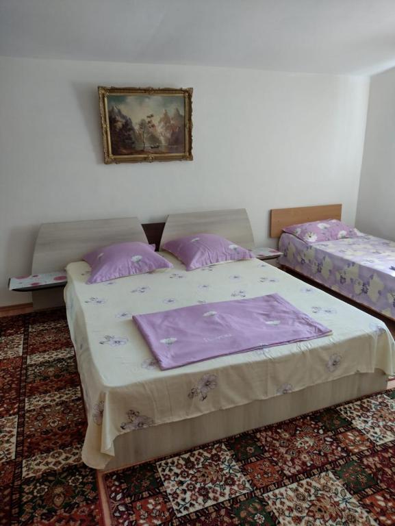 two beds in a room with a painting on the wall at Tanta in Tuzla