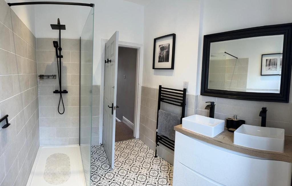 a bathroom with a shower and a sink and a mirror at Four Bedroom High Spec Victorian Townhouse in Clitheroe