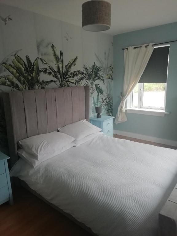 a bedroom with a white bed and a window at LOCH CONNELL LODGE rooms 1 2 3 4 5 in Letterkenny