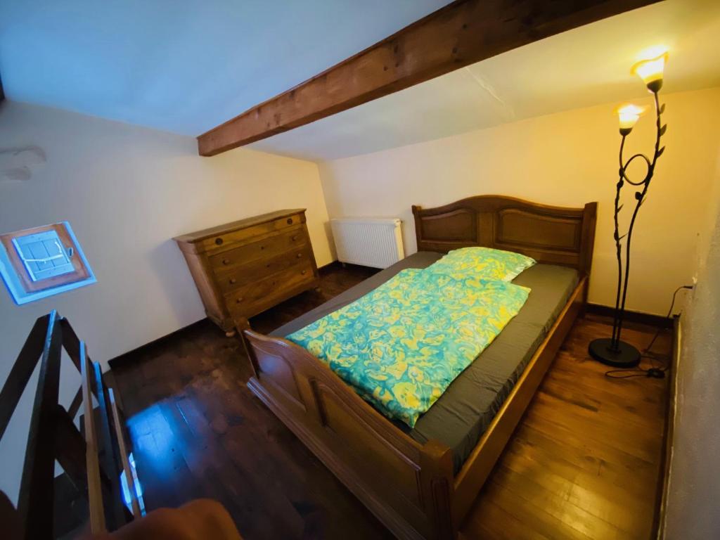 a bedroom with a wooden bed and a dresser at Mas du petit Félix in Pompignan