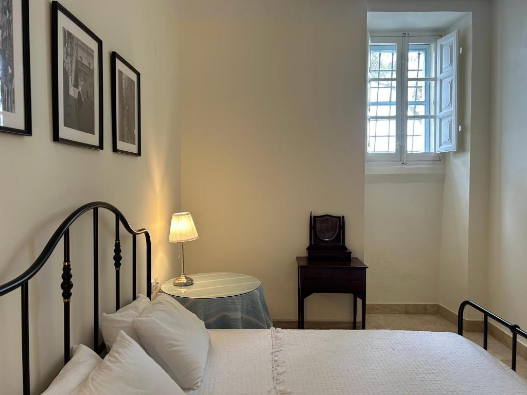 una camera con letto e tavolo con orologio di Prestigious Pied a Terre Wignacourt with views a La Valletta