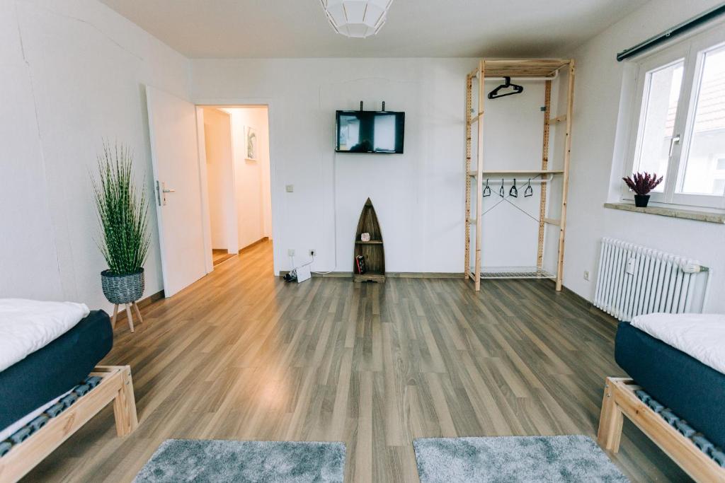 a living room with two beds and a wooden floor at City Apartment Singen in Singen