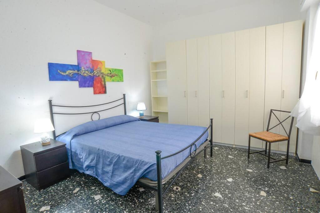 a bedroom with a bed with a blue bedspread at Casa Lella - VADOALMARE Immobiliare in Savona