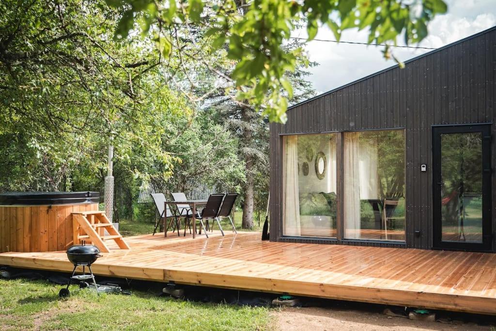 una piccola casa nera con terrazza in legno di Paluküla tiny house Kuuse a Paluküla