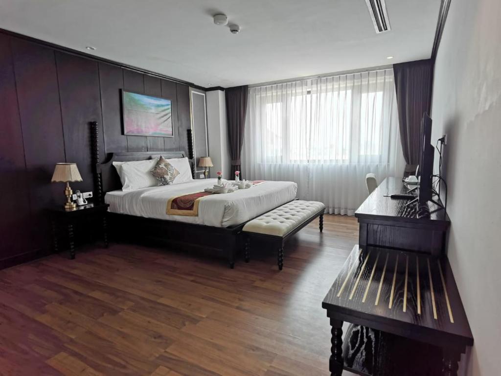 a bedroom with a large bed and a couch at Aaron Hotel in Vientiane