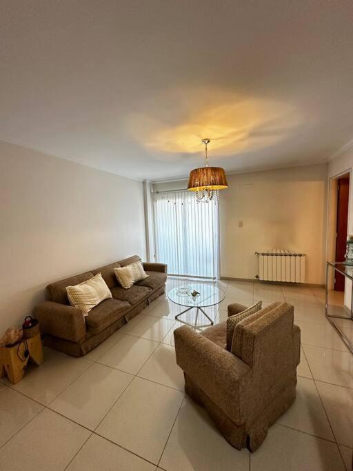 a living room with two couches and a glass table at Lugones House in Cordoba