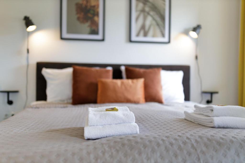 - une chambre avec un lit et des serviettes dans l'établissement VonMos Moselblick Apartments, à Kinheim