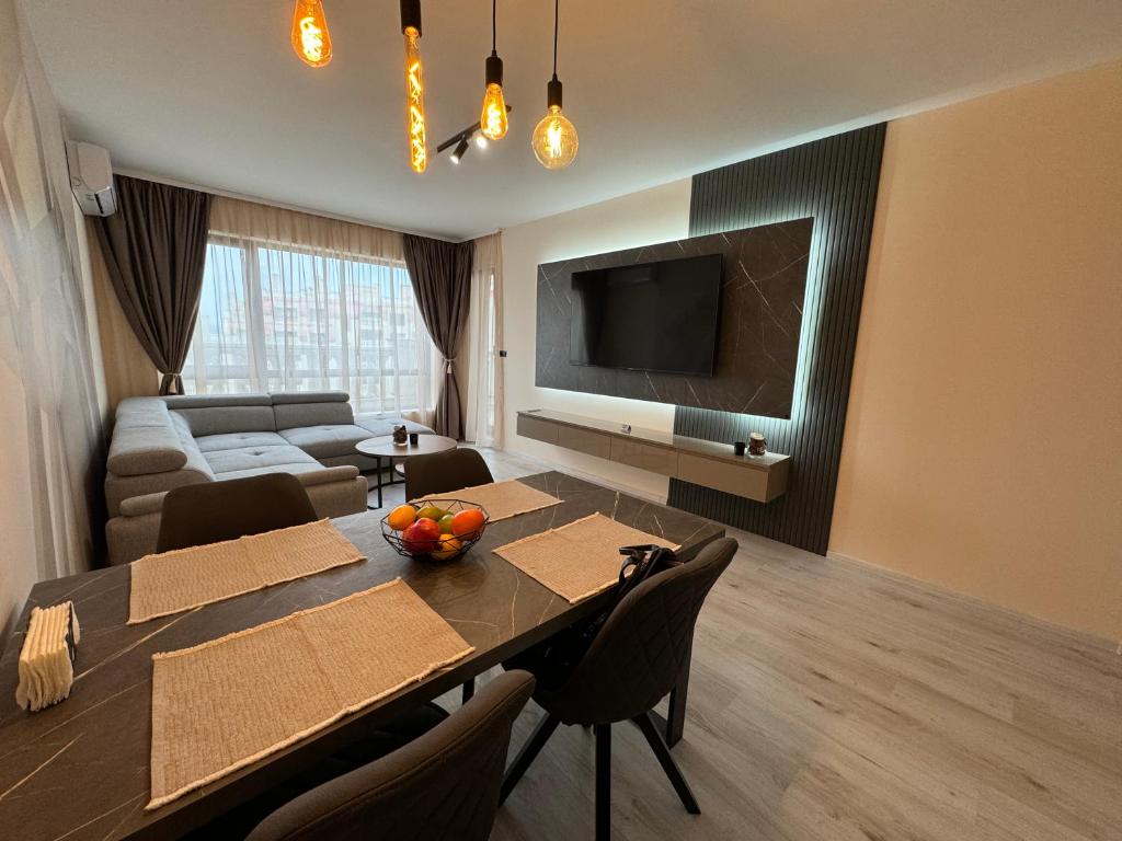 Sala de estar con mesa de comedor y TV en South Bay Luxury Apartment, en Varna