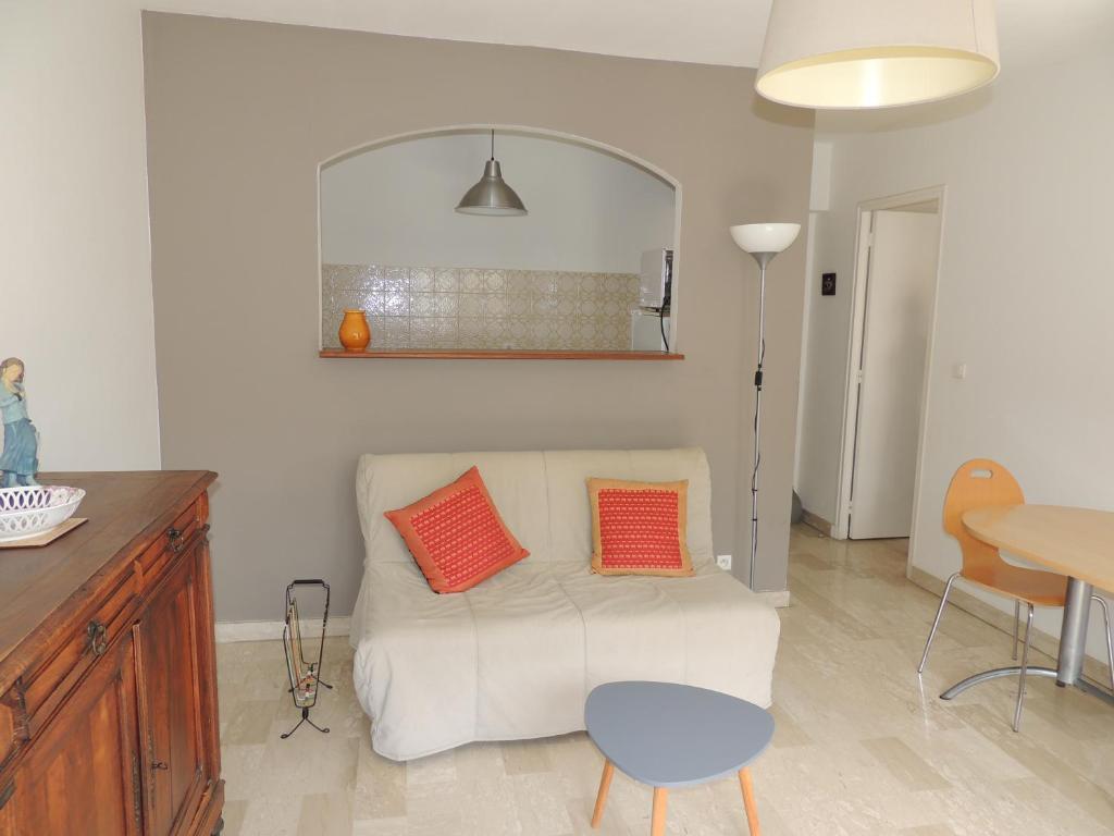 - un salon avec un canapé blanc et deux oreillers orange dans l'établissement T2 Centre-ville, proche plage, à Sanary-sur-Mer