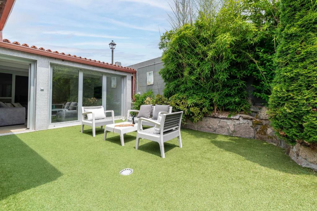 a yard with two chairs and a ball on the grass at La Casita de Alcabre in Vigo