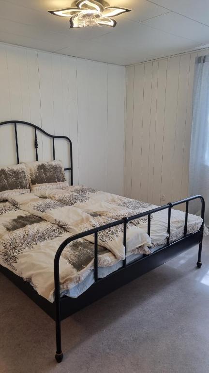 a bed in a room with a black frame at Sackle's place in Pori