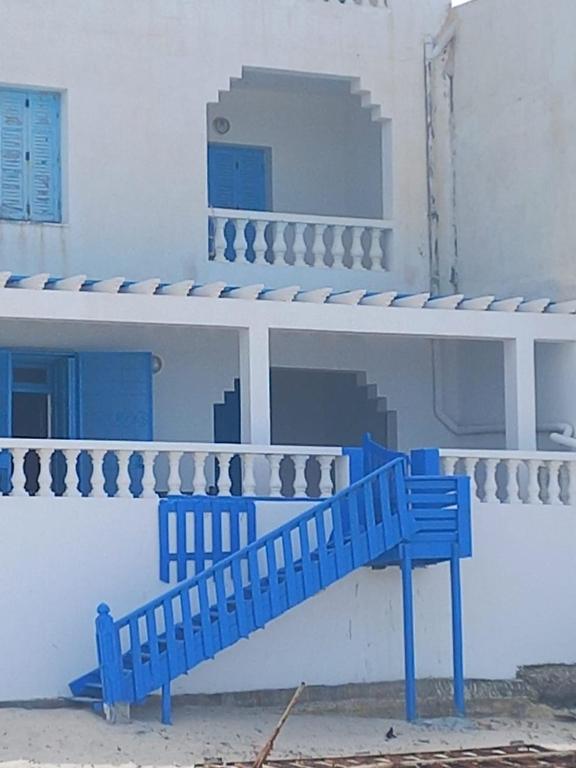 a blue bench sitting in front of a white building at Résidence lalla baya appart 1 in Sousse