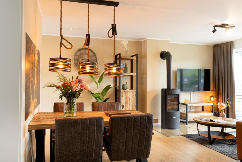 a dining room with a wooden table with chairs at Residences Central Winterberg in Winterberg