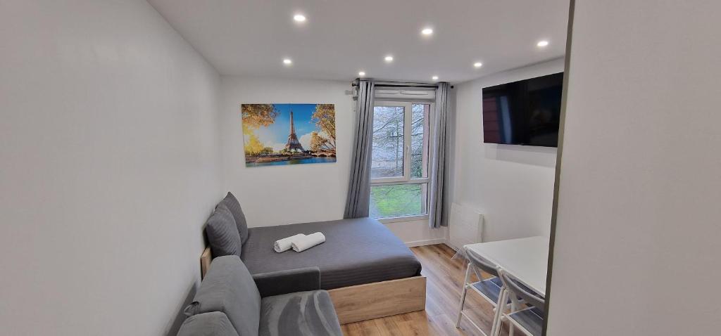 Cette petite chambre comprend un canapé et une fenêtre. dans l'établissement Studio Disneyland RER 4 pers, à Montévrain
