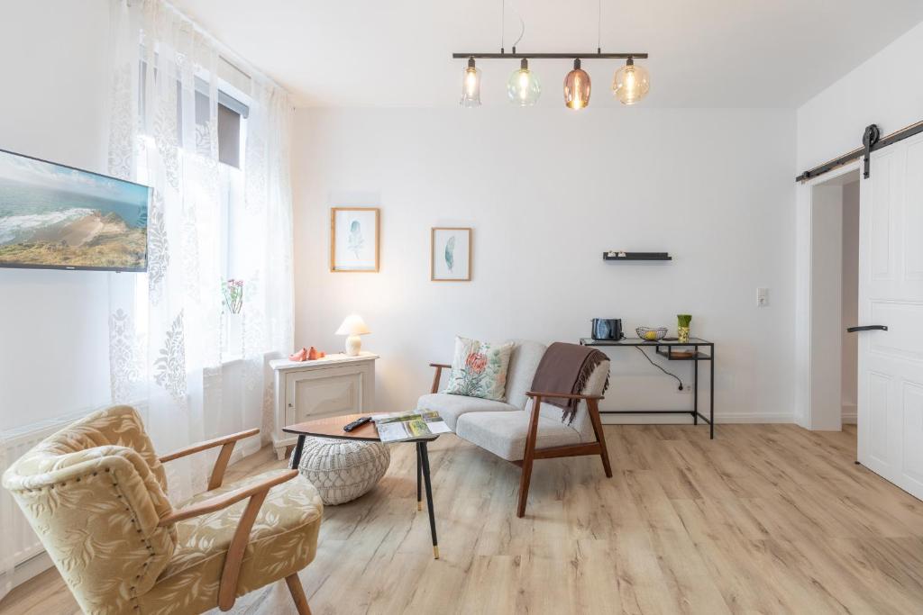 a living room with chairs and a table at Buchenheinrich Karlas blau Stuuv in Garding