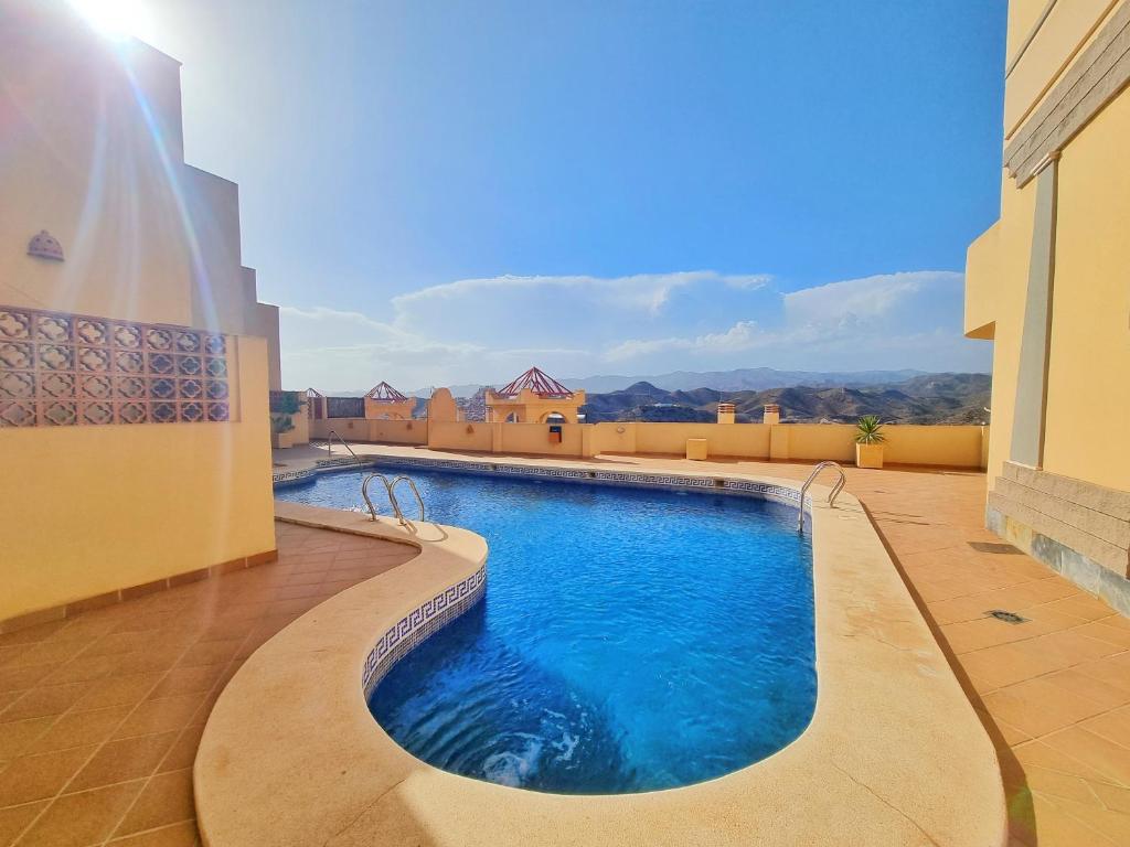 a swimming pool in the middle of a building at Apartamento con piscina, urbanización privada by AlohaPalma in Águilas