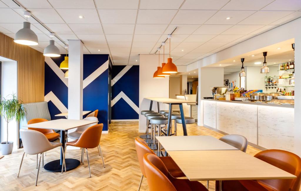 a restaurant with tables and chairs and a kitchen at ibis budget Leicester in Leicester