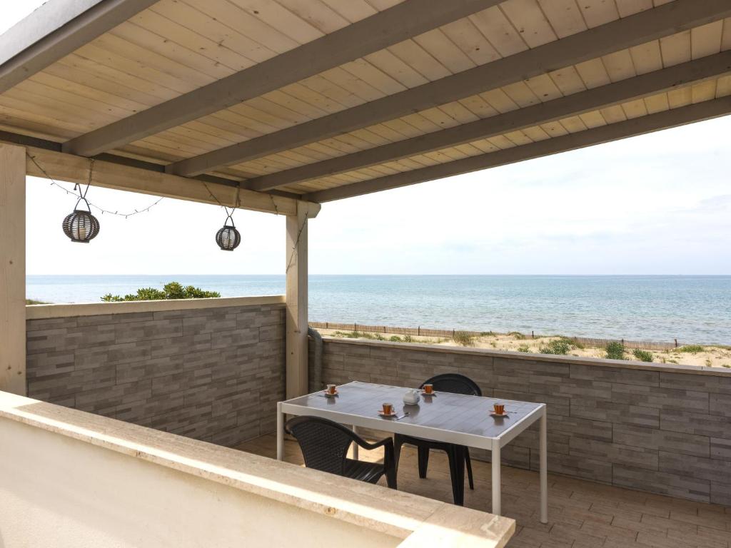 Un patio con mesa y vista al mar. en Apartment Rome's Beach House 1 by Interhome, en Torvaianica