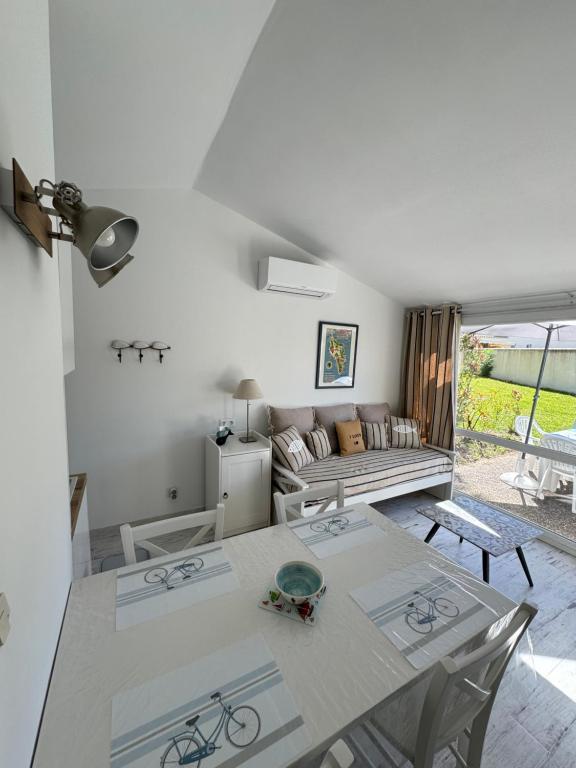 a living room with a table and a couch at La Maison des Vacances in Dolus d'Oléron