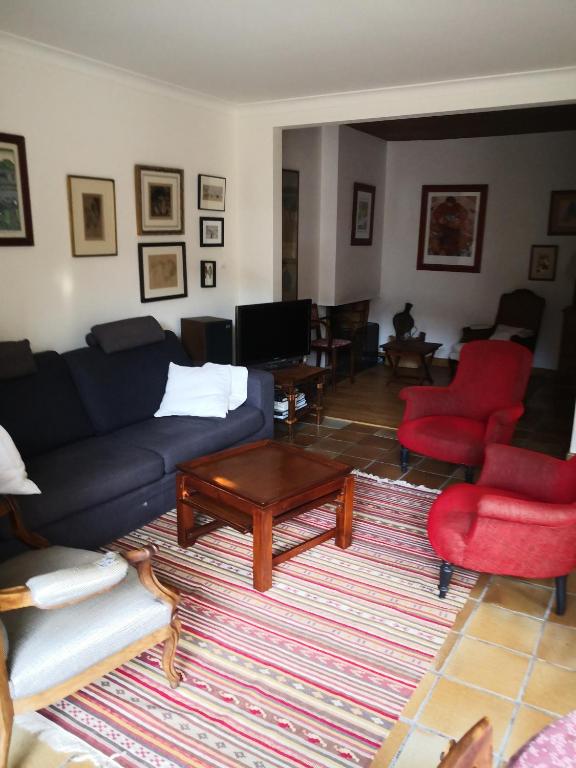 - un salon avec un canapé bleu et des fauteuils rouges dans l'établissement Maison centre ville avec jardin, à Concarneau