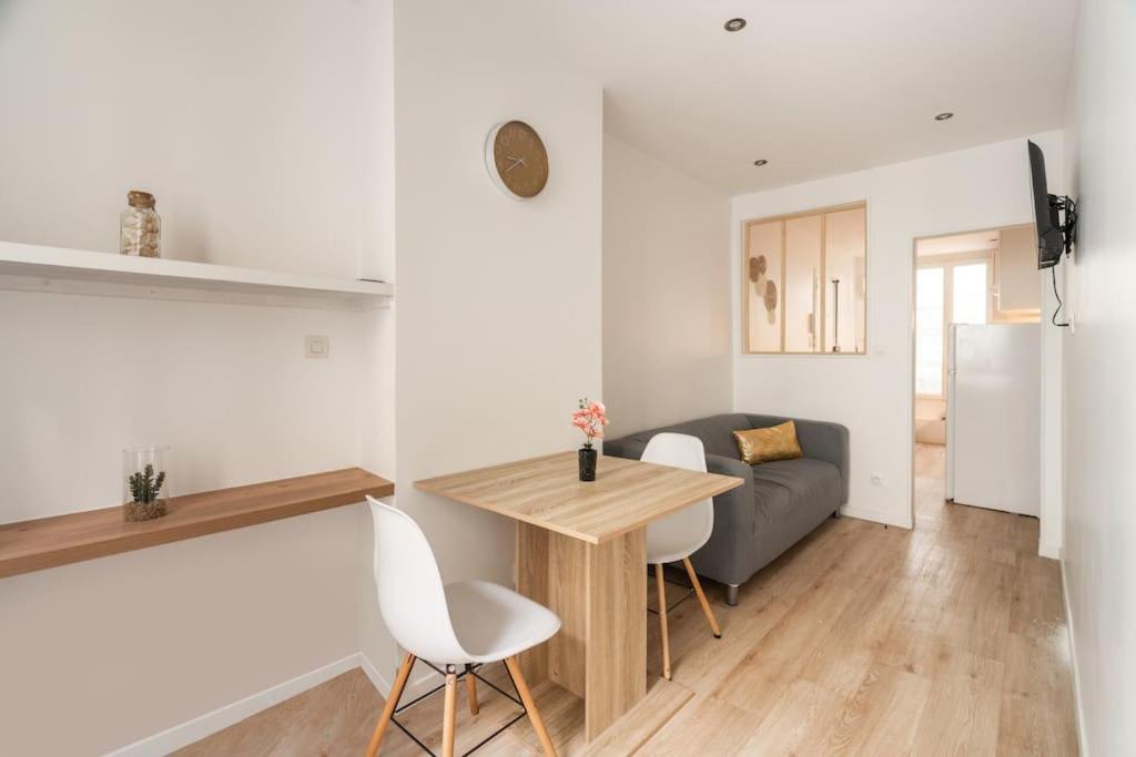 une cuisine et un salon avec une table et un canapé dans l'établissement Appartement cosy canal Saint Martin, à Paris