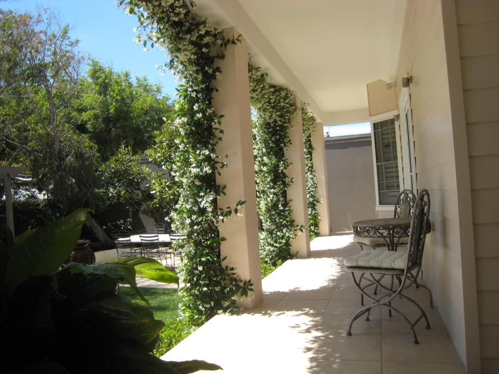a patio with ivy on the side of a house at Brezza Bella Boutique Bed & Breakfast in Merewether