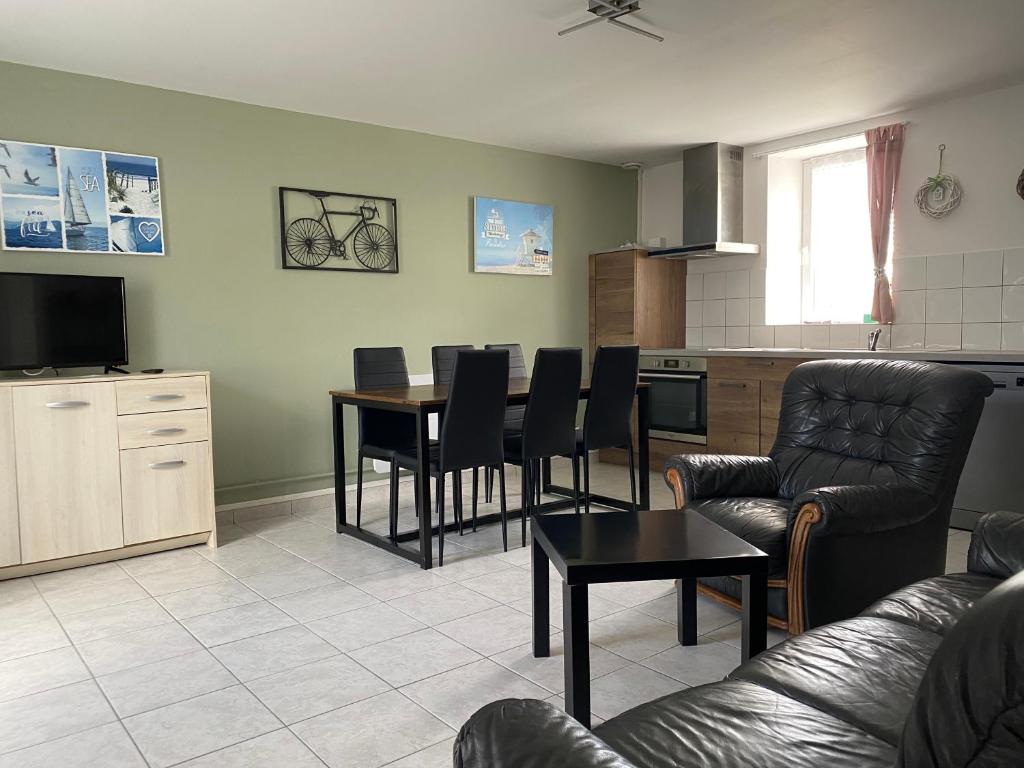 un salon avec une table et des chaises et une cuisine dans l'établissement Appartement 2 chambres et cuisine-salon Plages du Débarquement, à Vierville-sur-Mer