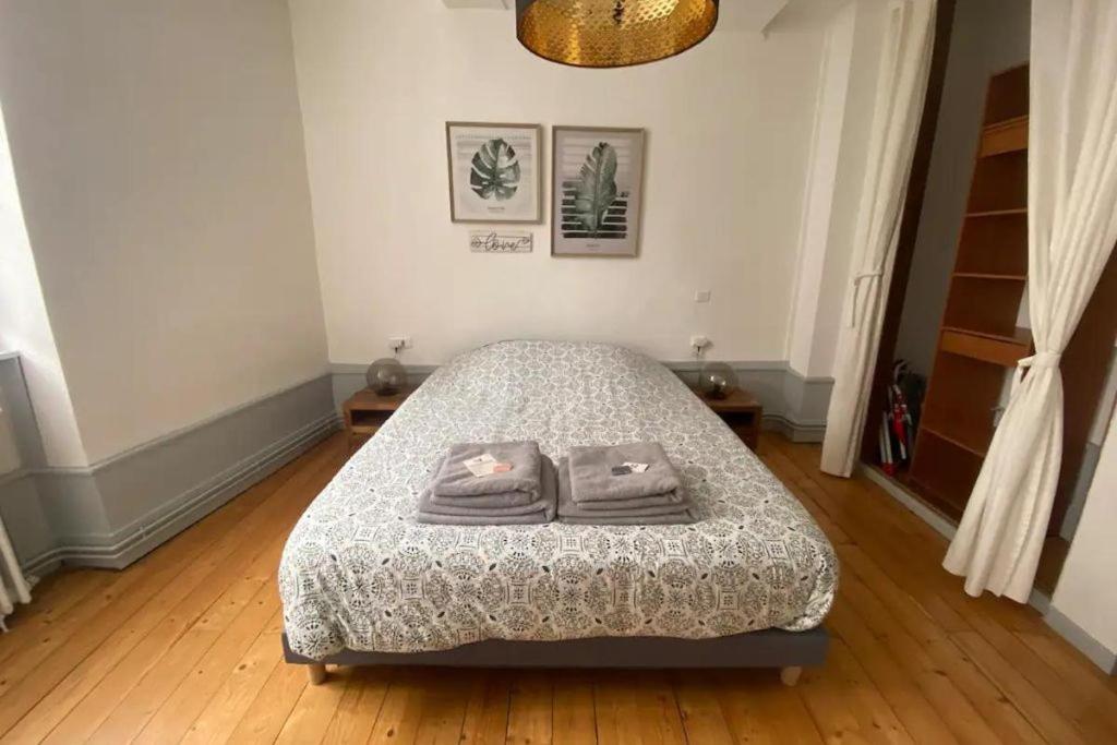 une chambre avec un lit avec deux serviettes dessus dans l'établissement Le Grilleton, à Dole