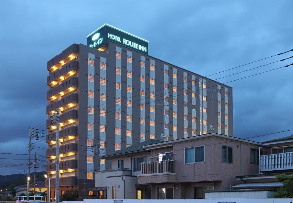 a hotel building with a sign on top of it at Hotel Route Inn Isehara Ooyama Inter -Kokudo 246 Gou- in Isehara