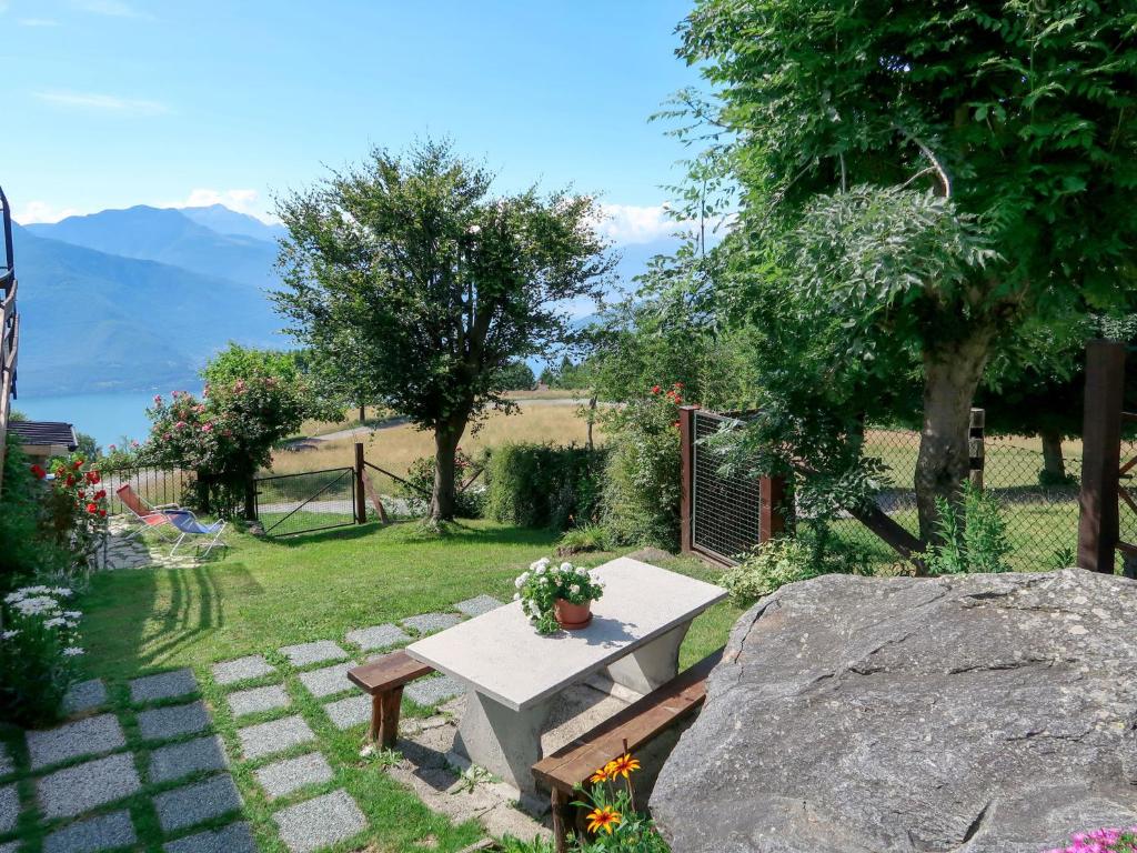 a garden with a bench and a table with flowers at Apartment Mia e Giulia by Interhome in Dosso del Liro