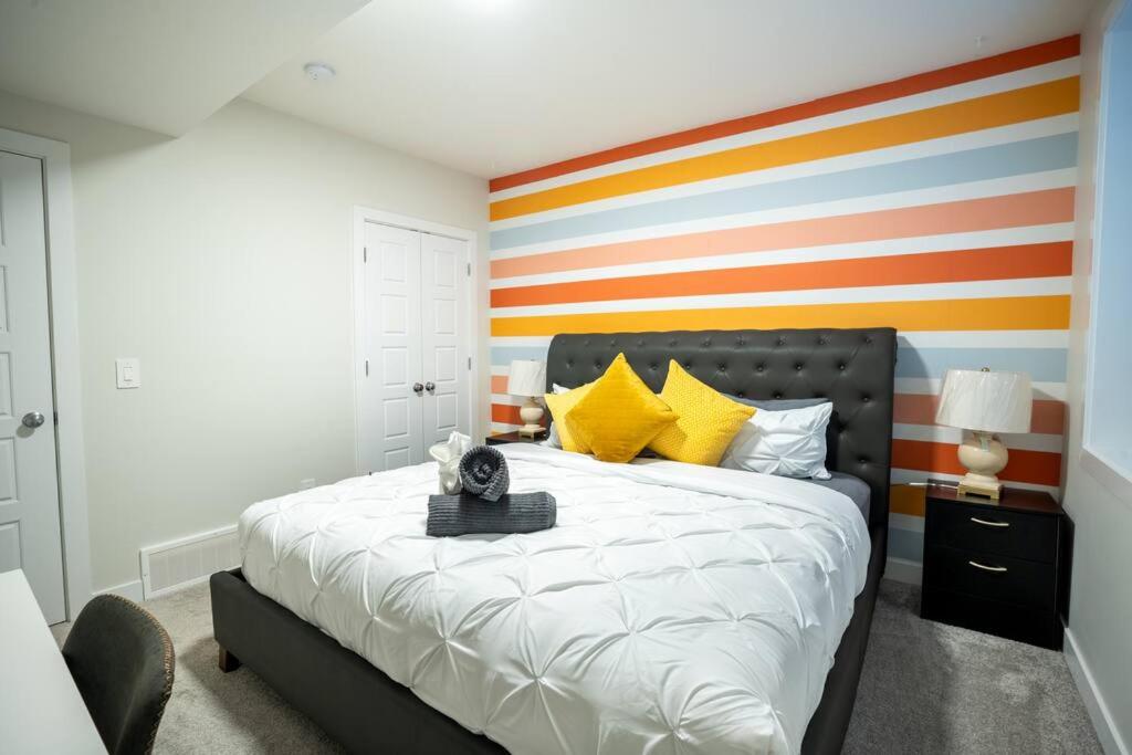 a bedroom with a bed with a colorful striped wall at Warm getaway Perfect for 4 in Edmonton