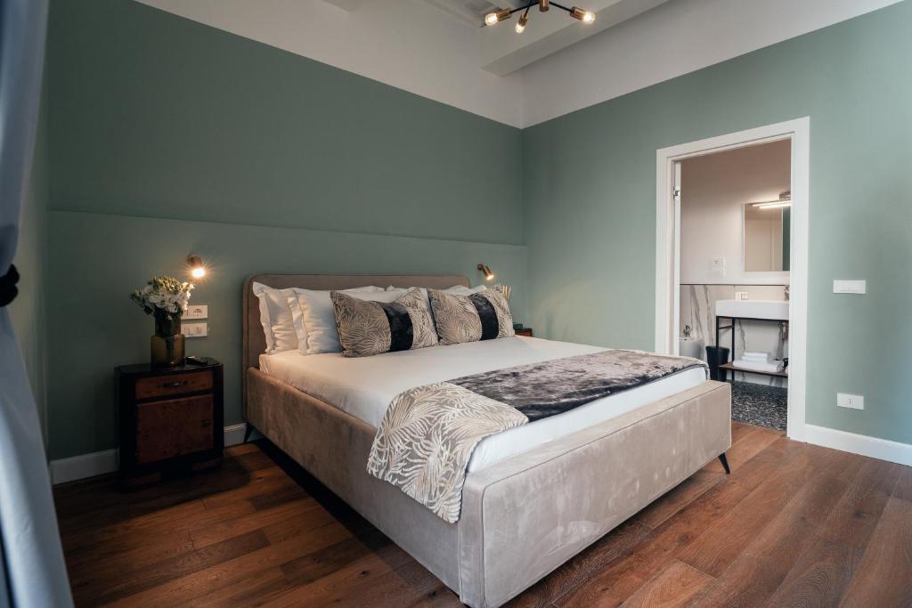 a bedroom with a large bed with blue walls at NAMAN HOTELLERIE - Monti in Rome