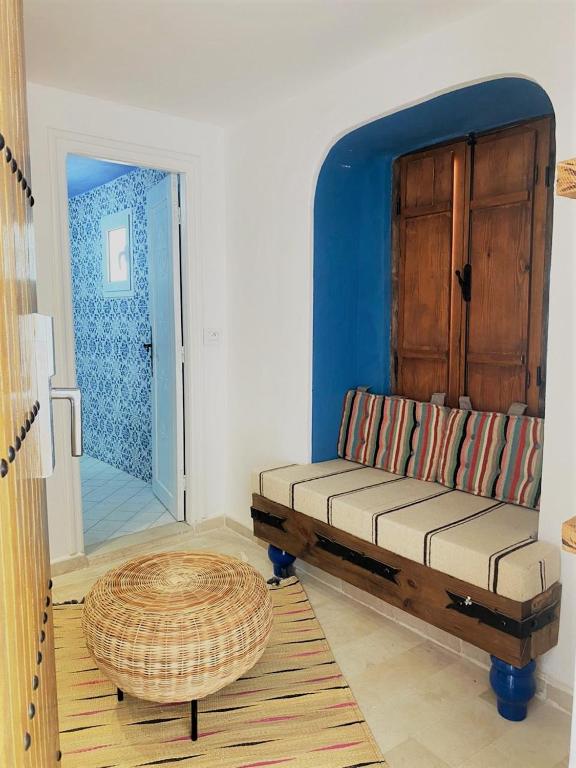 a living room with a bench and a door at Hôtel Djerba Authentique - Au centre de Midoun in Midoun