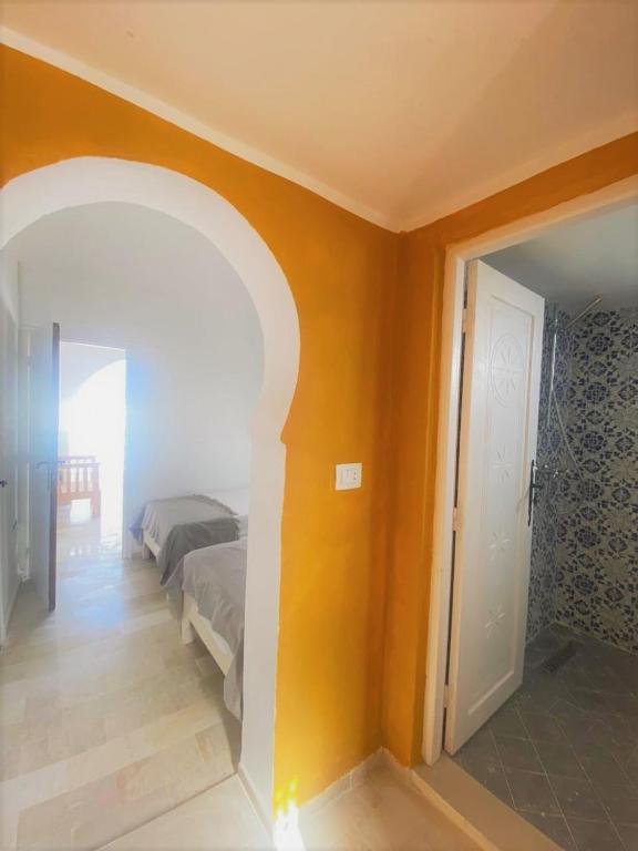 a bedroom with a bed and an open door at Hôtel Djerba Authentique - Au centre de Midoun in Midoun