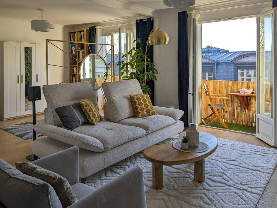 un salon avec un canapé et une table dans l'établissement Appartement Versailles, à Versailles