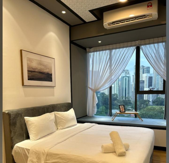 ein Schlafzimmer mit einem Bett und einem großen Fenster in der Unterkunft Ceylonz Suite By ANA MALAYSIA in Kuala Lumpur