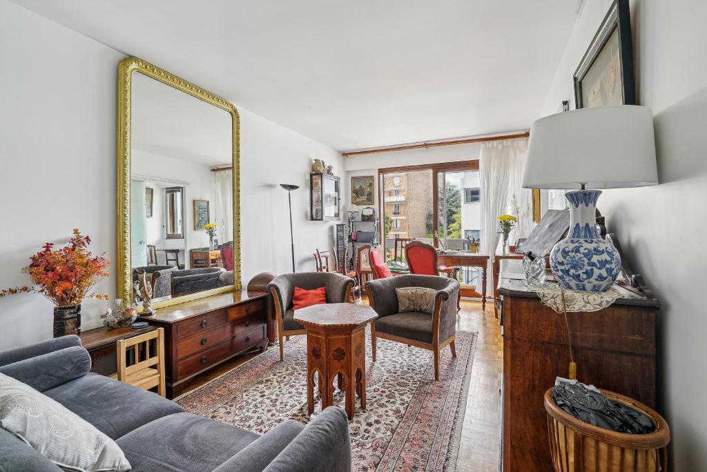 un salon avec un canapé et un miroir dans l'établissement Appartement de charme dans le Saint-Lambert by Weekome, à Paris