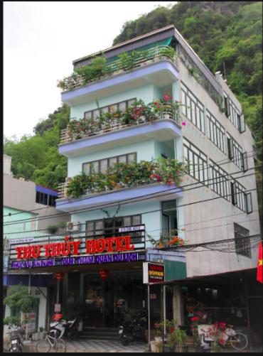a building with flower boxes on the side of it at Thu Thủy Hotel in Cat Ba