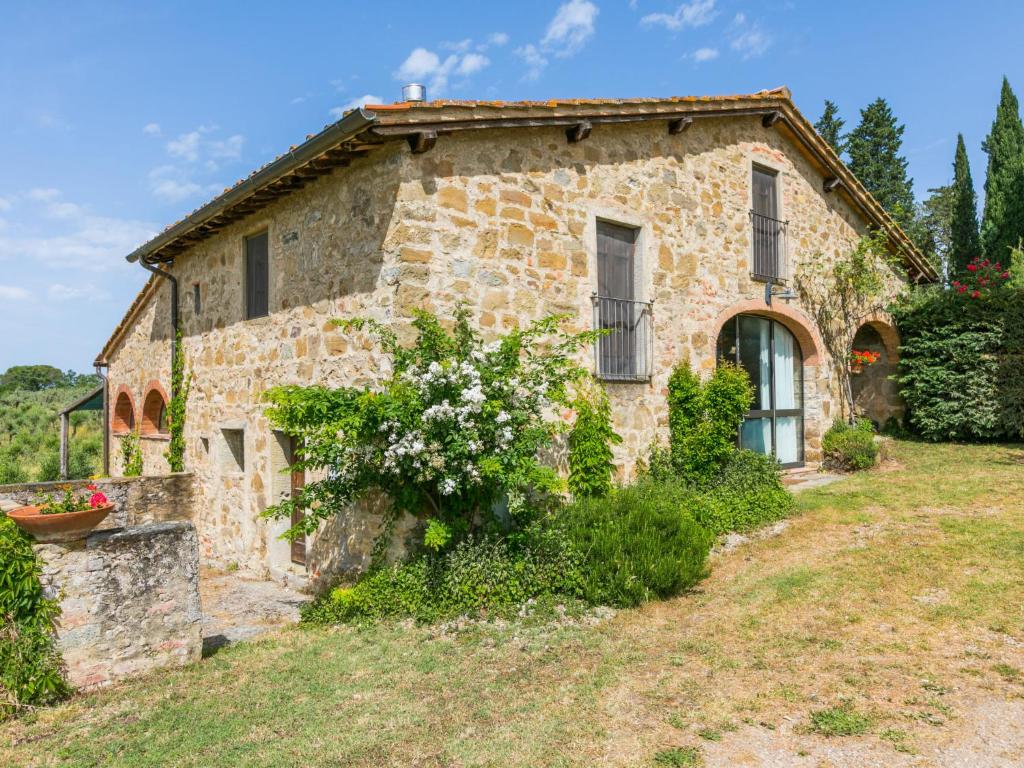 une vieille maison en pierre avec des fleurs devant dans l'établissement Holiday Home Il Forno by Interhome, à Pergine Valdarno