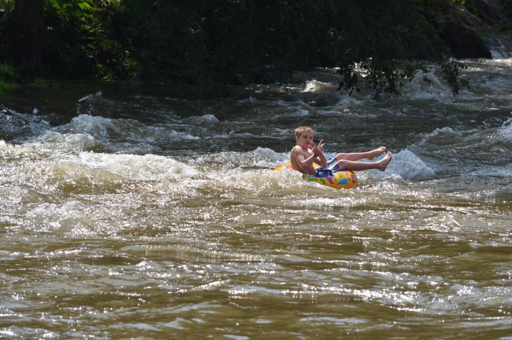 a young boy sitting on a raft in a river at Creekstone Inn in Pigeon Forge