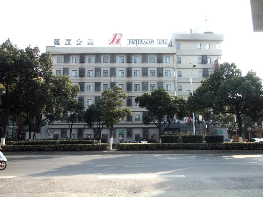 een groot wit gebouw met een bord erop bij Jinjiang Inn Wuxi Liangxi Road Wanda Plaza in Wuxi