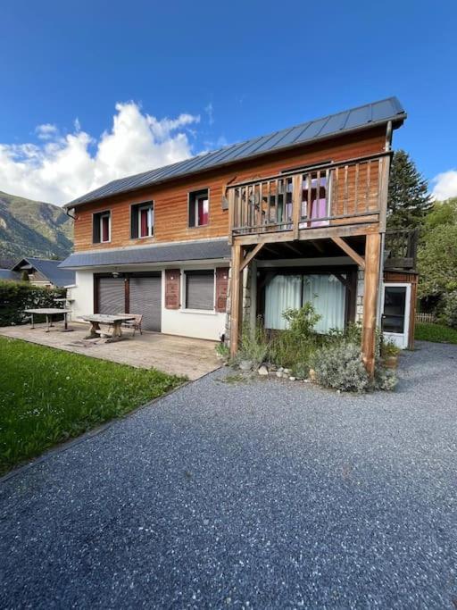 une maison avec une terrasse et un banc devant elle dans l'établissement Super appartement à Saint Lary, à Saint-Lary-Soulan