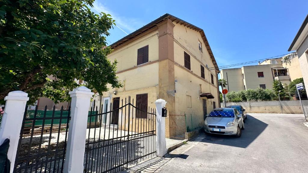 a car parked in front of a building with a fence at SE104 - Elegante quadrilocale comodo ai servizi in Senigallia