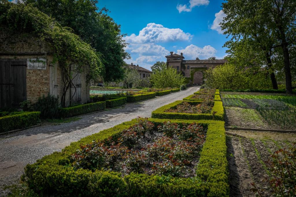a garden with bushes and flowers on a road at Antica Corte Pallavicina Relais in Polesine Parmense